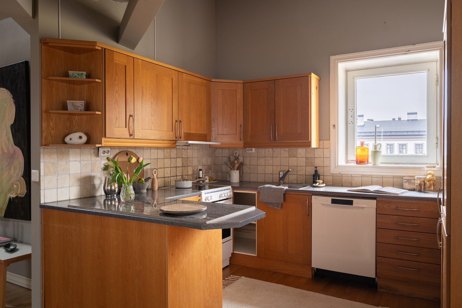 Innredningen har profilerte fronte, laminert benkeplate med nedfelt oppvaskkum og fliser i benkeryggen. Vinduet slipper inn fint naturlig arbeidslys. Galleribilde