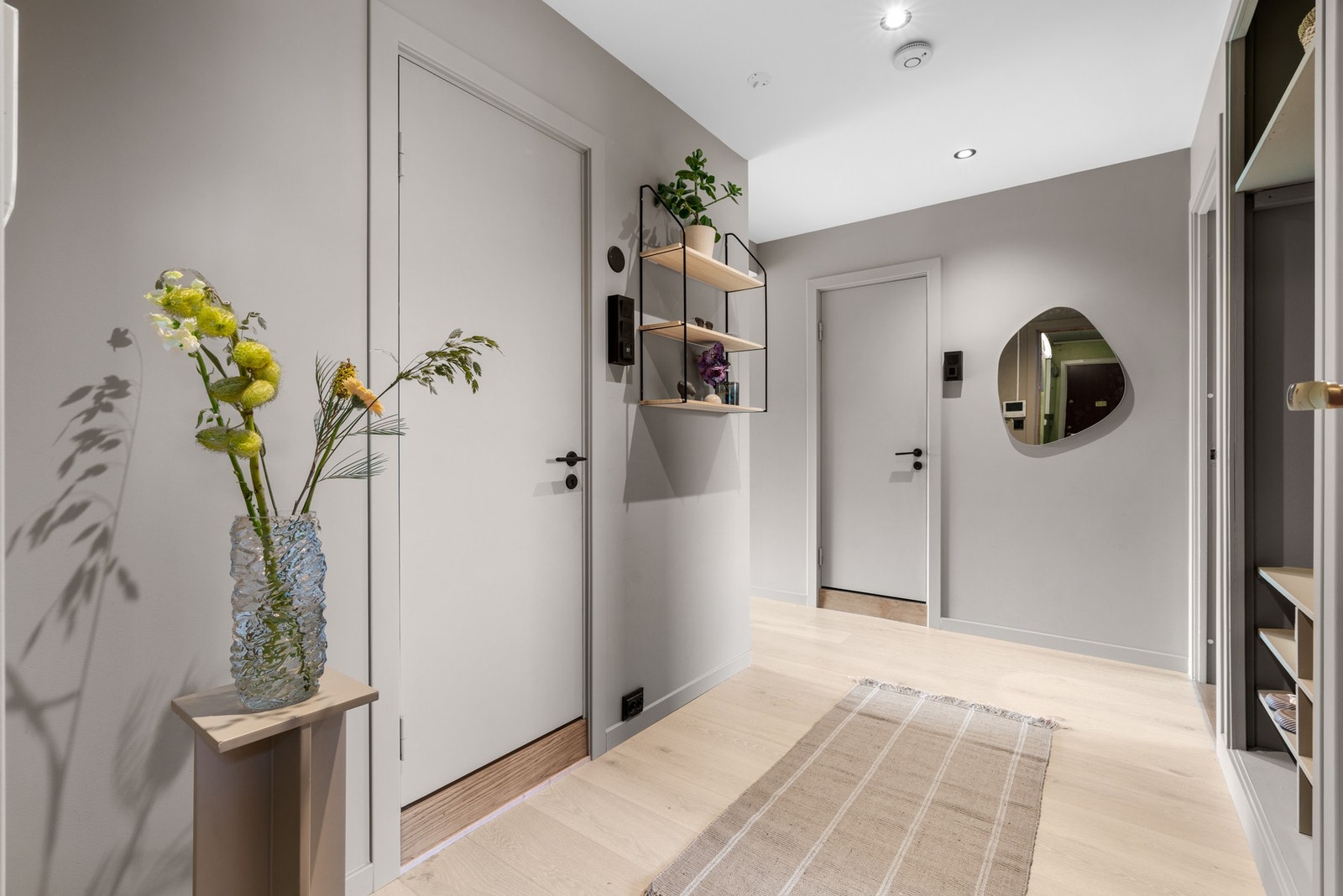 Entréen er romslig med parkett på gulv, glattmalte flater på vegg malt i en delikat og harmonisk farge og downlights i tak Galleribilde