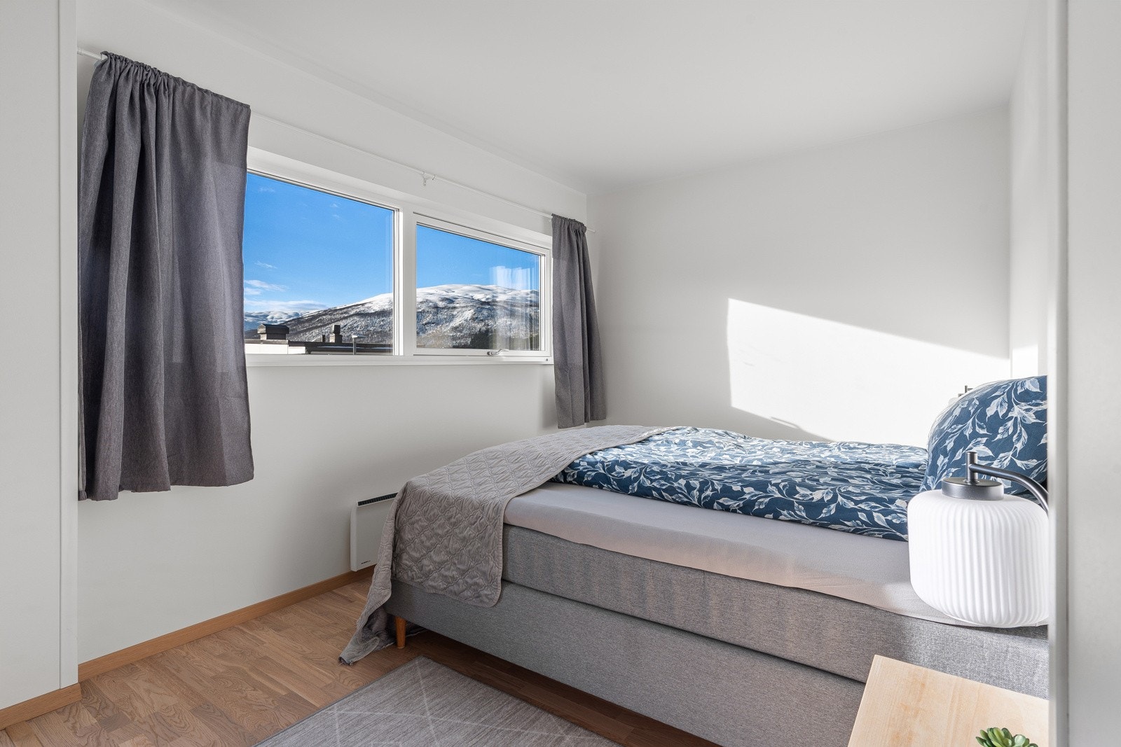 God plass til stor seng og tilhørende nattbord.