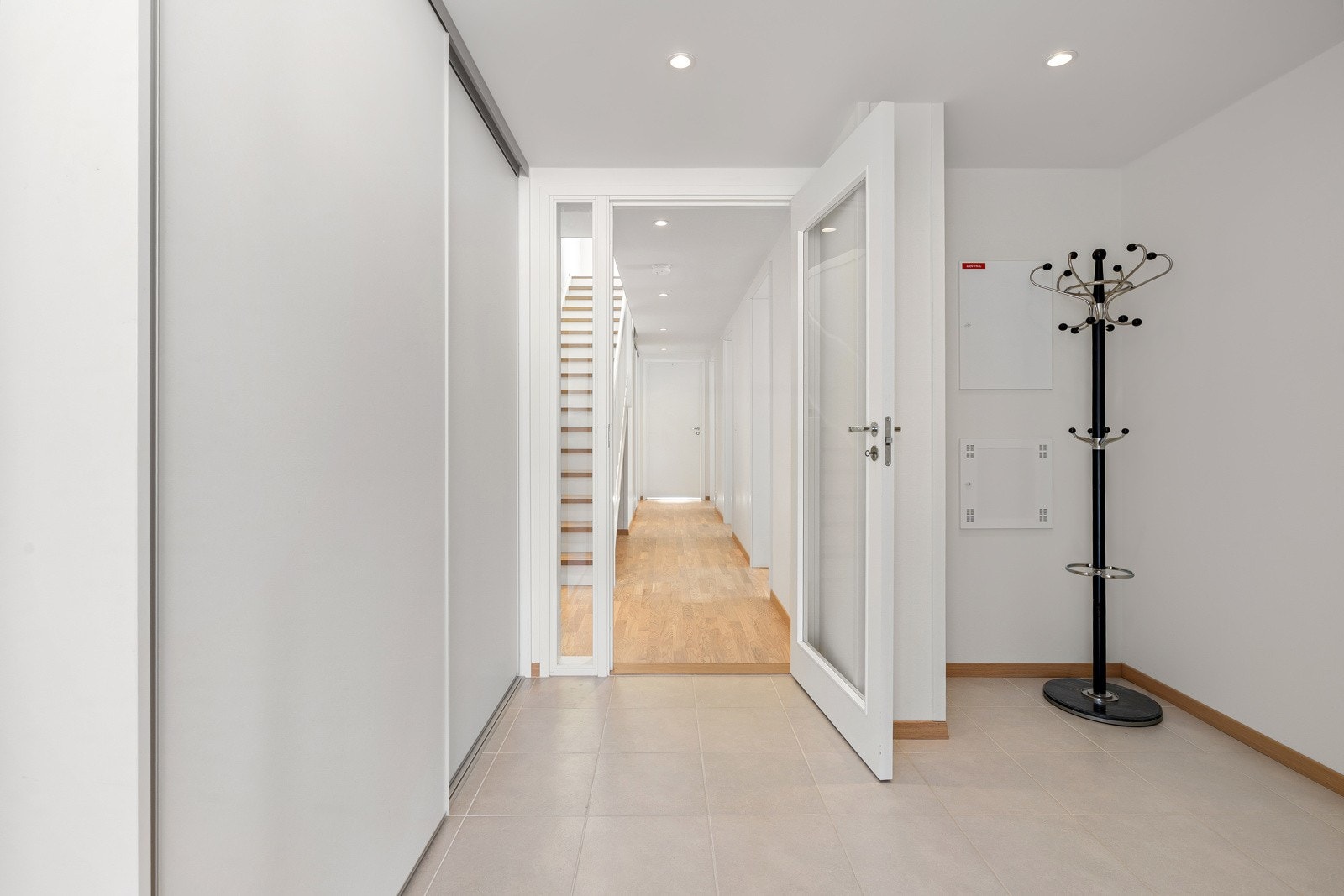 Romslig entrè med flislagt gulv.