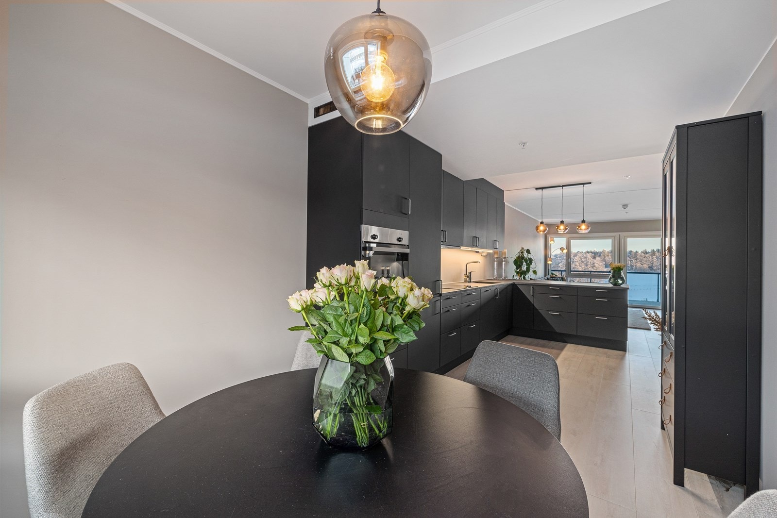 Fra kjøkkenet kan man holde samtalen i gang med familie eller gjester som har funnet seg til rette ved spisebordet. Galleribilde