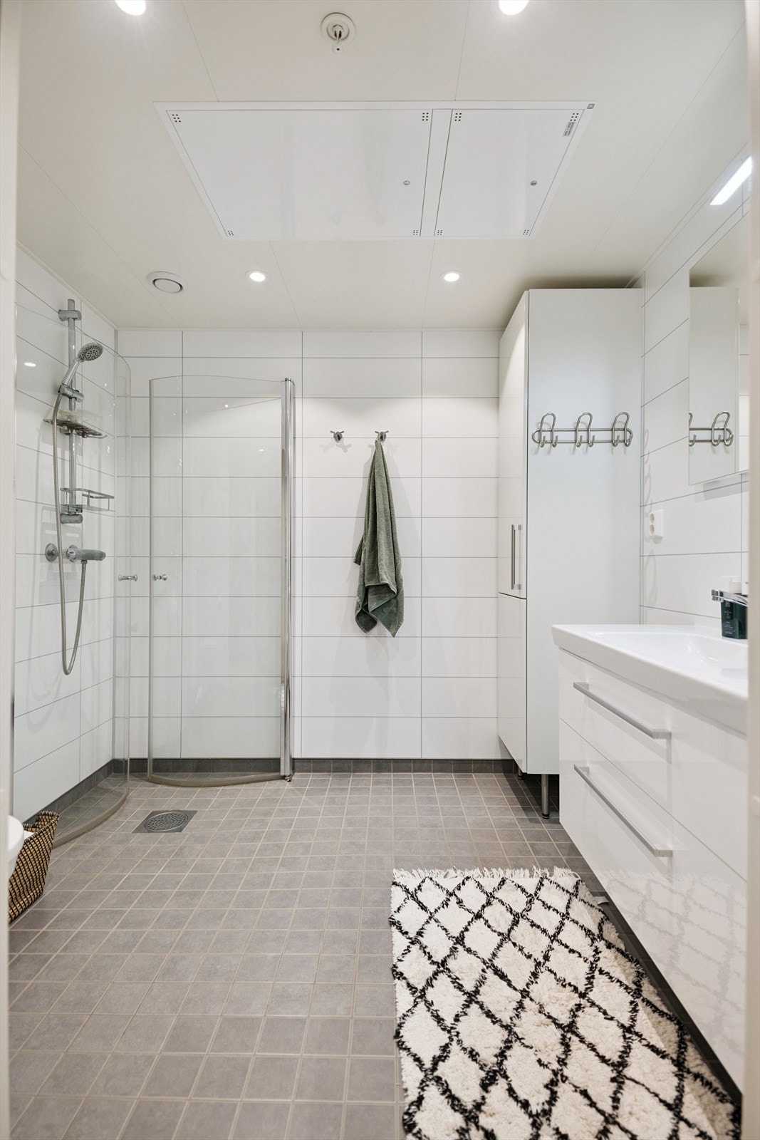 Badet har flislagt gulv med vannbåren gulvvarme og innfellbare dusjdører i glass. Galleribilde