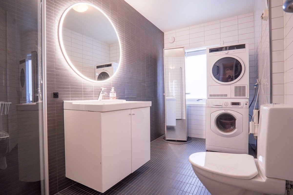 Badet har varmekabler i gulvet og stort speil med LED-belysning Galleribilde