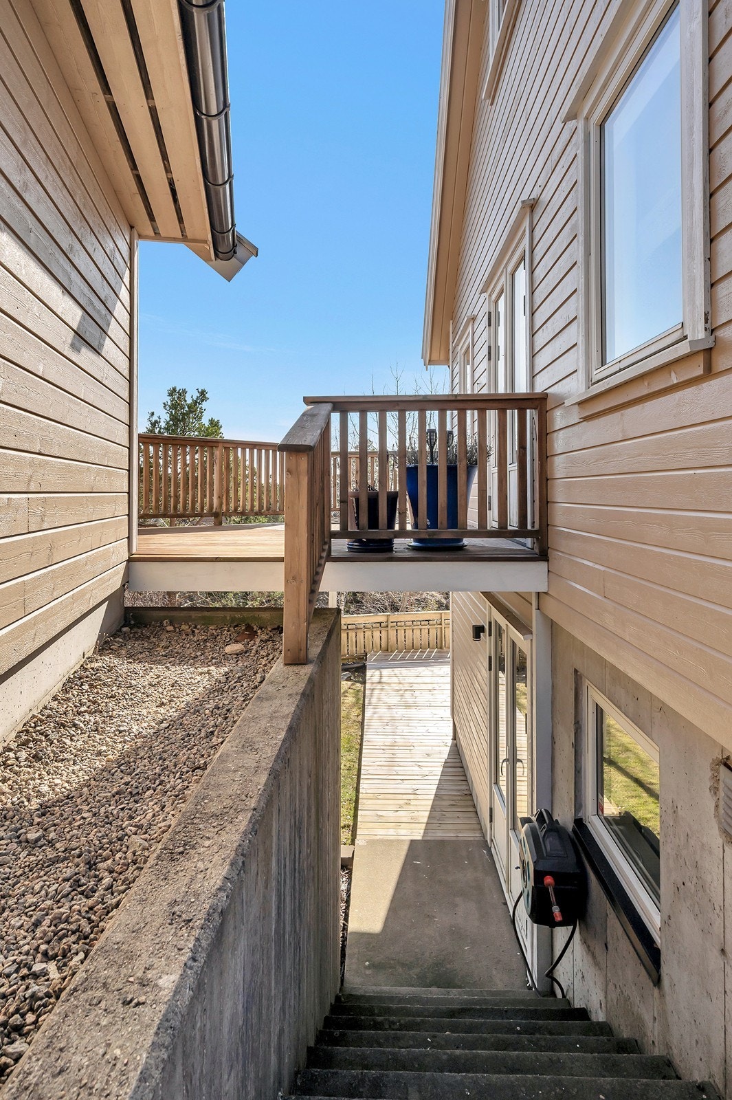 Passasje med trapp ned til uteplassen mellom garasjen og boligen. Meget praktisk og anvendelig. Galleribilde