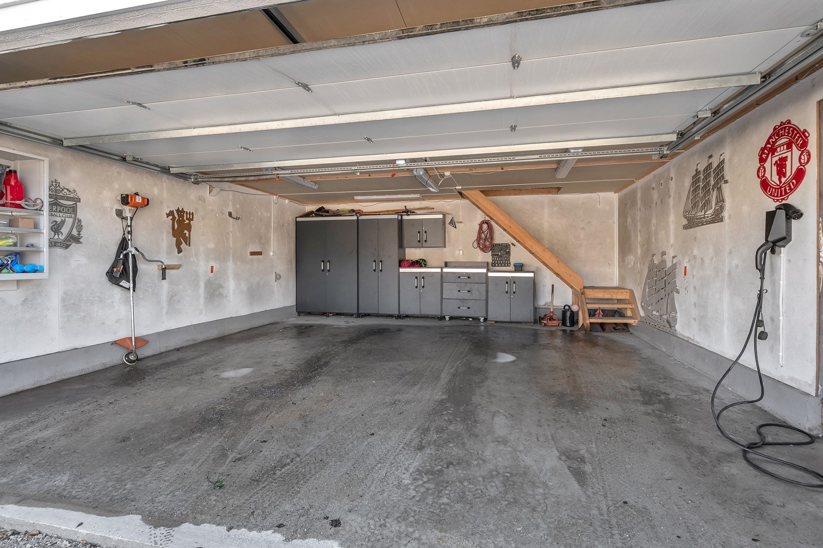 Med boligen følger denne store garasjen med loft og elbillader. Her er det også elektrisk port. Galleribilde