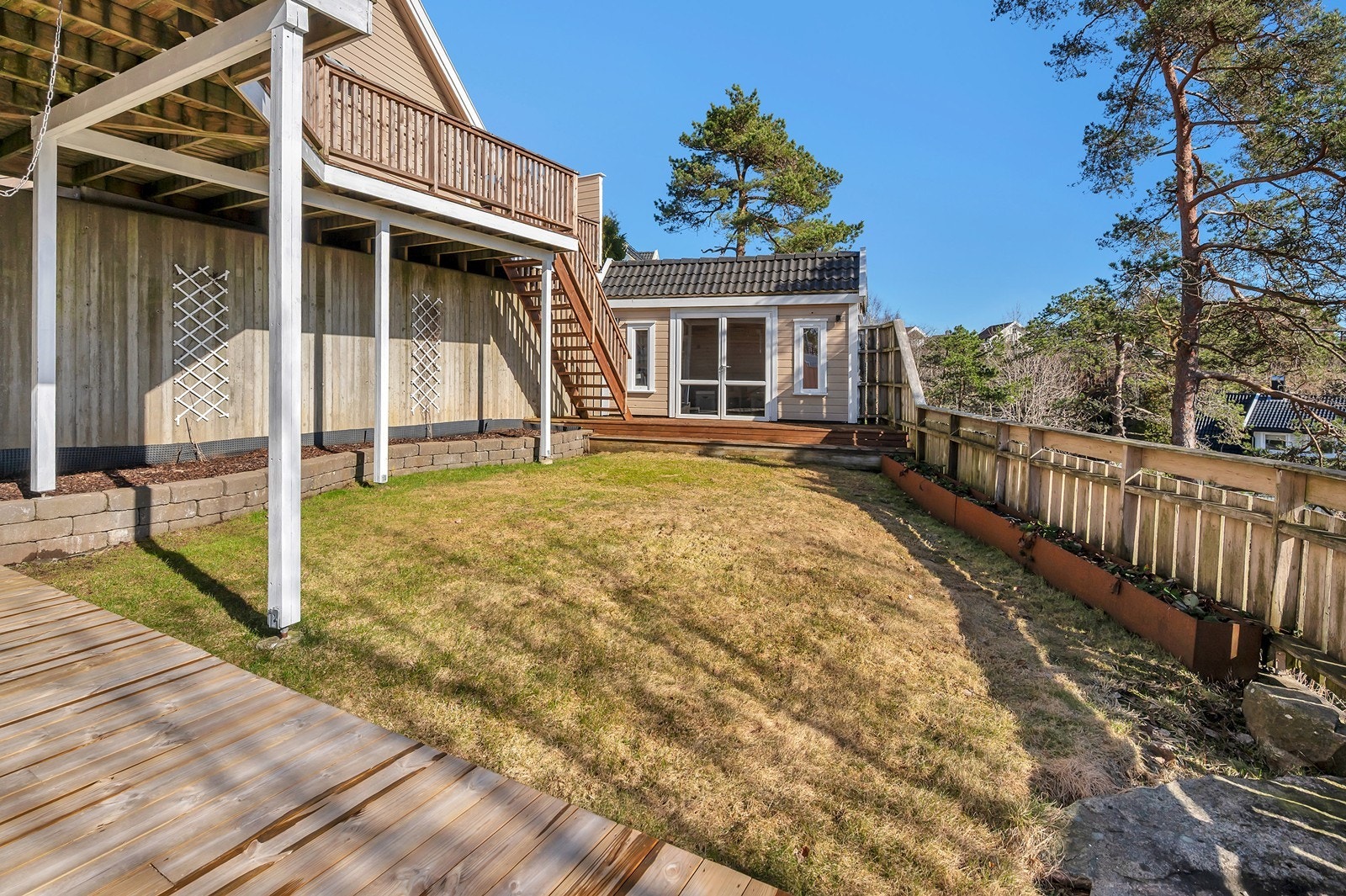 Fra verandaen er det trapp ned til hagen. meget praktisk og anvendelig. Det opplyses om at hagestue/bod er pålagt fjernet av kommunen. Galleribilde