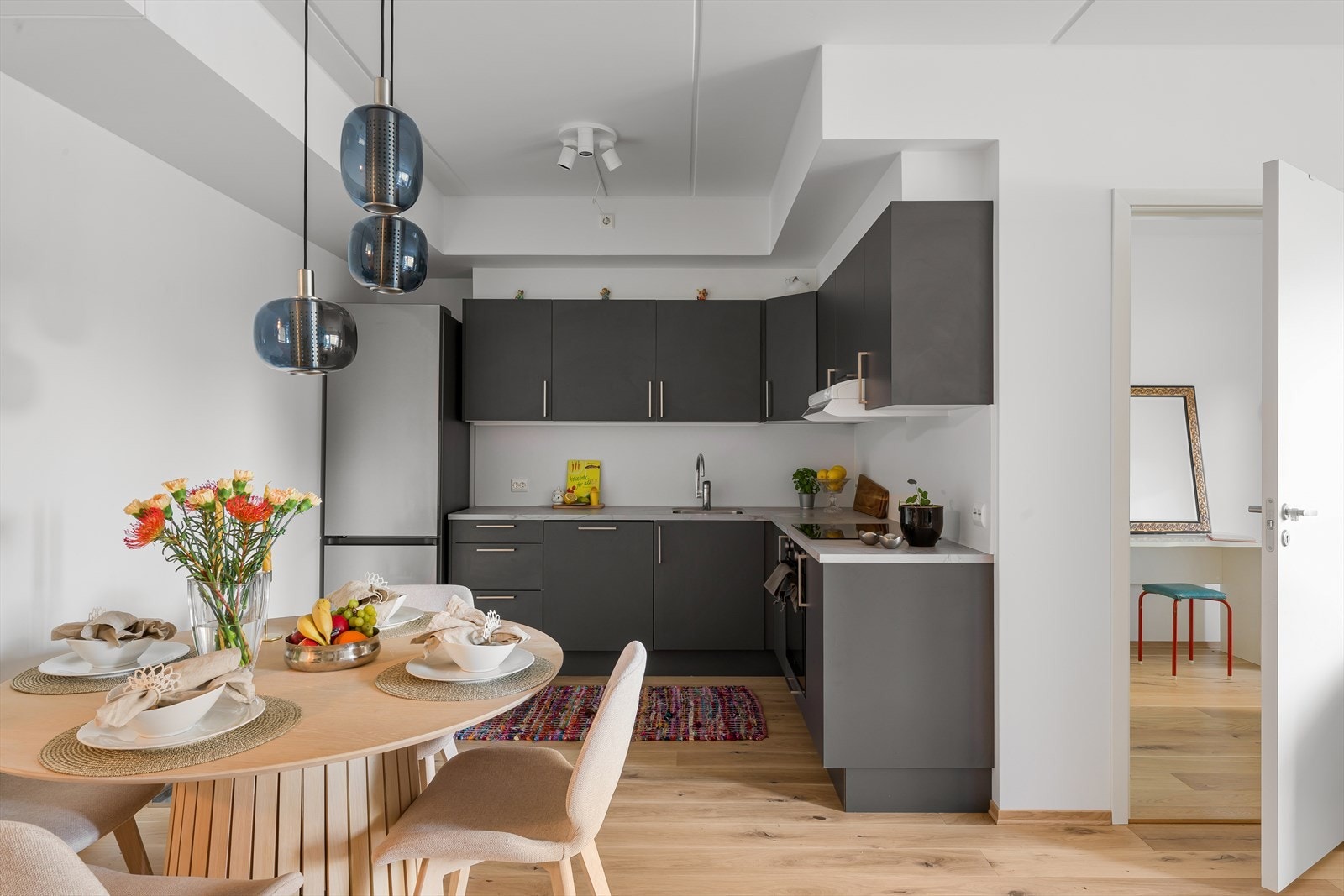 Moderne kjøkkeninnredning med integrerte løsninger og plass til hyggelig spisegruppe. Galleribilde