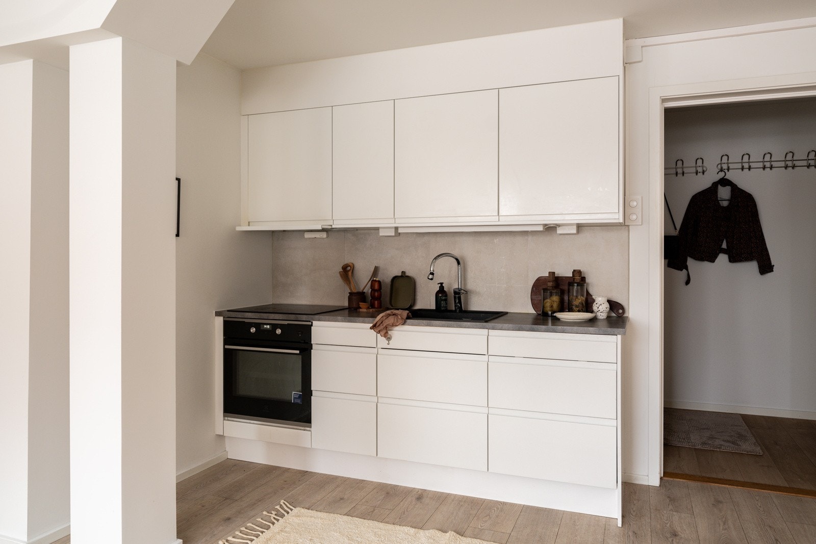 Både fint og praktisk med flotte fliser i benkeryggen og belysning under de takhøye overskapene. Galleribilde