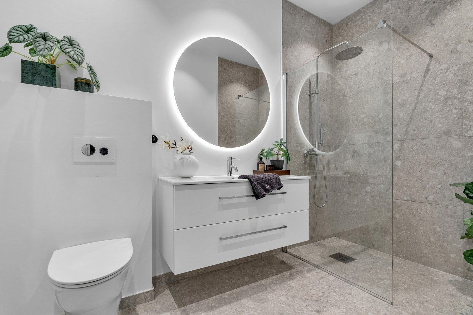 Stilrent bad med store fliser og påkostede materialvalg. Galleribilde