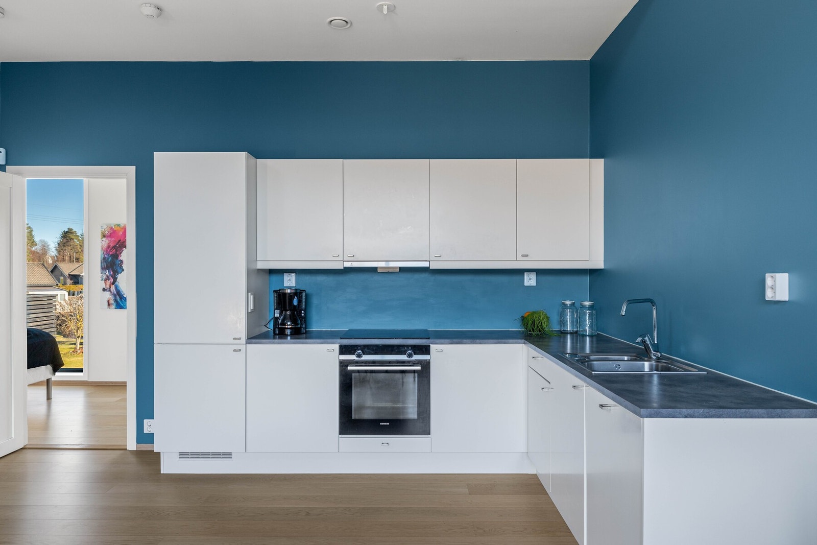 Moderne kjøkken med slette fronter og integrerte hvitevarer. Galleribilde