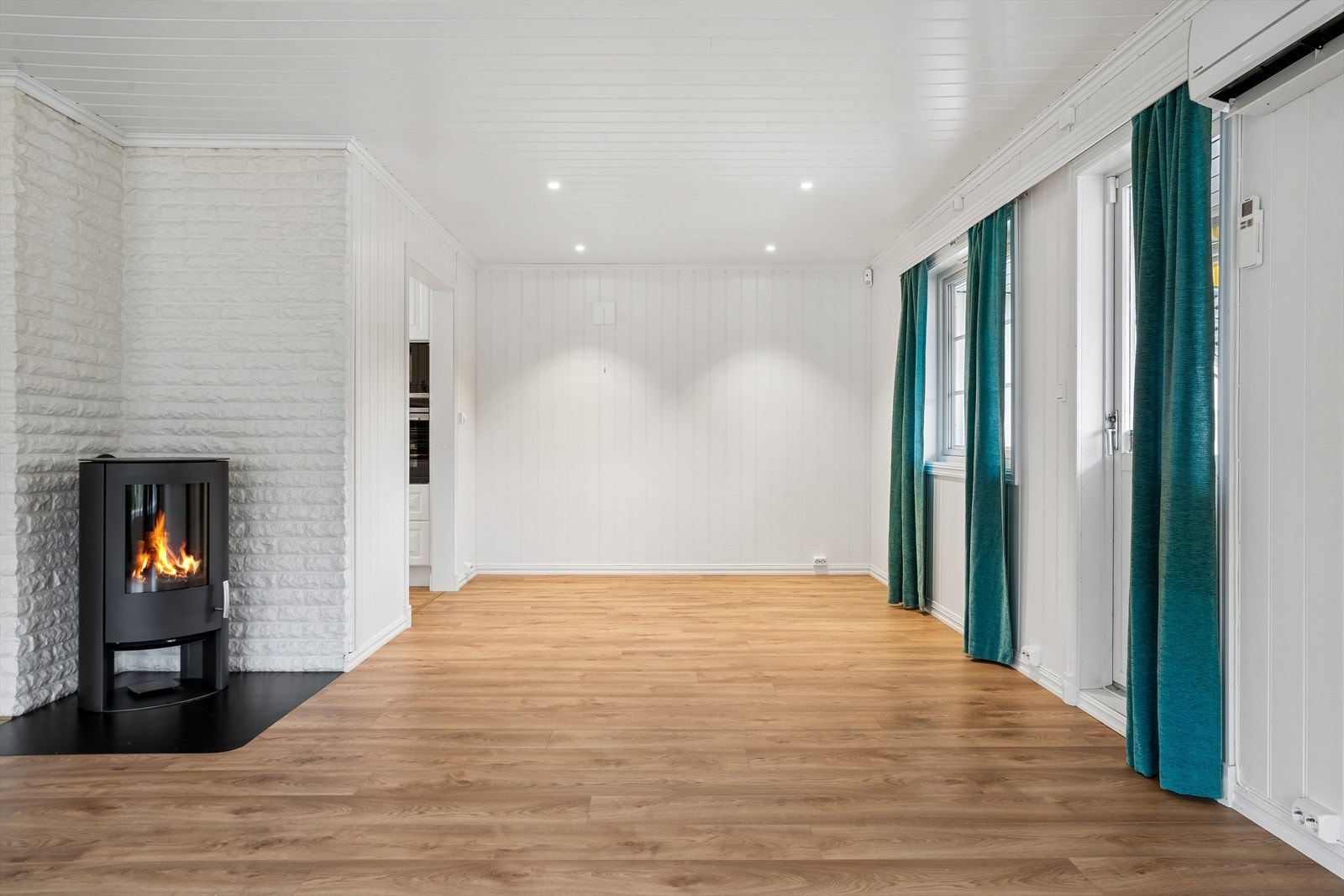 Vinkelformet stue med plass til spisestue og sofagruppe. Galleribilde