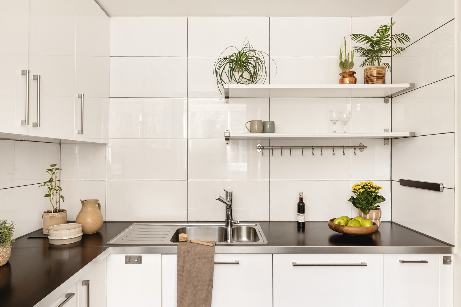 Kjøkkenet består av slette fronter, laminat på gulv og benkeplate, over benkeplaten er det benyttet fliser, stål oppvaskkum og ventilator. Galleribilde