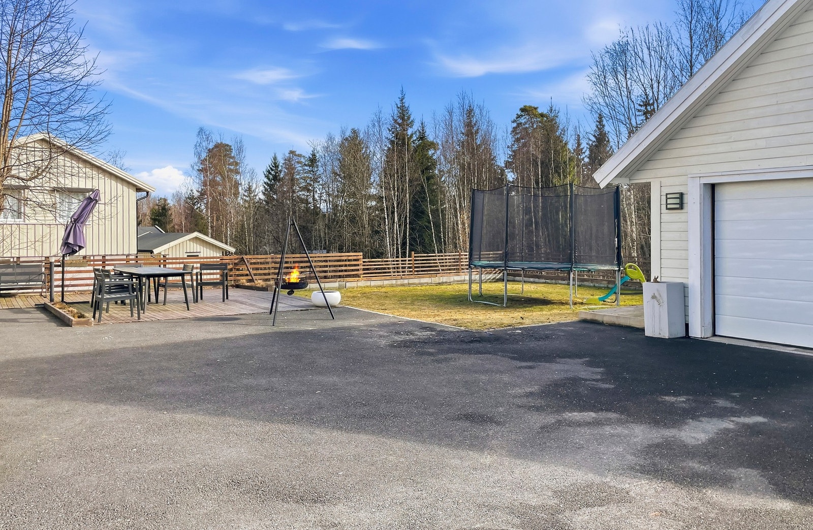 Flat og meget barnevennlig tomt med gressplen, platting og asfaltert vei. Galleribilde