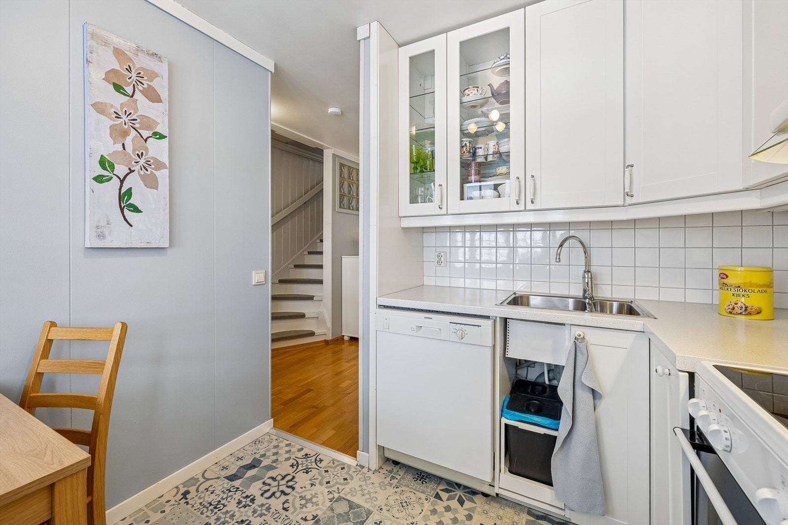 Kjøkkenet har en praktisk utforming med laminert benkeplate og fliser over benken. Galleribilde