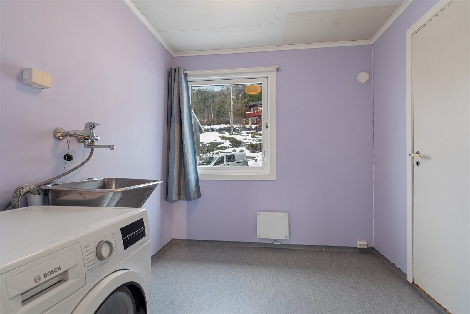 Separat vaskerom med opplegg for vaskemaskin og utslagsvask på vegg. Galleribilde