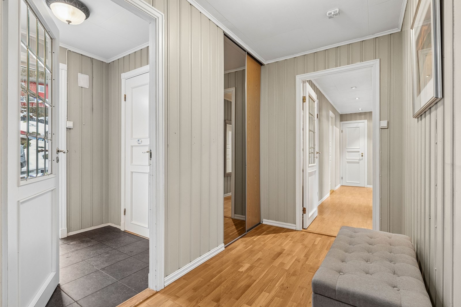 Lys og hyggelig entré/gang med innebygget skyvedørsgarderobe, samt plass for mindre garderobe- og opphengsløsninger. Galleribilde