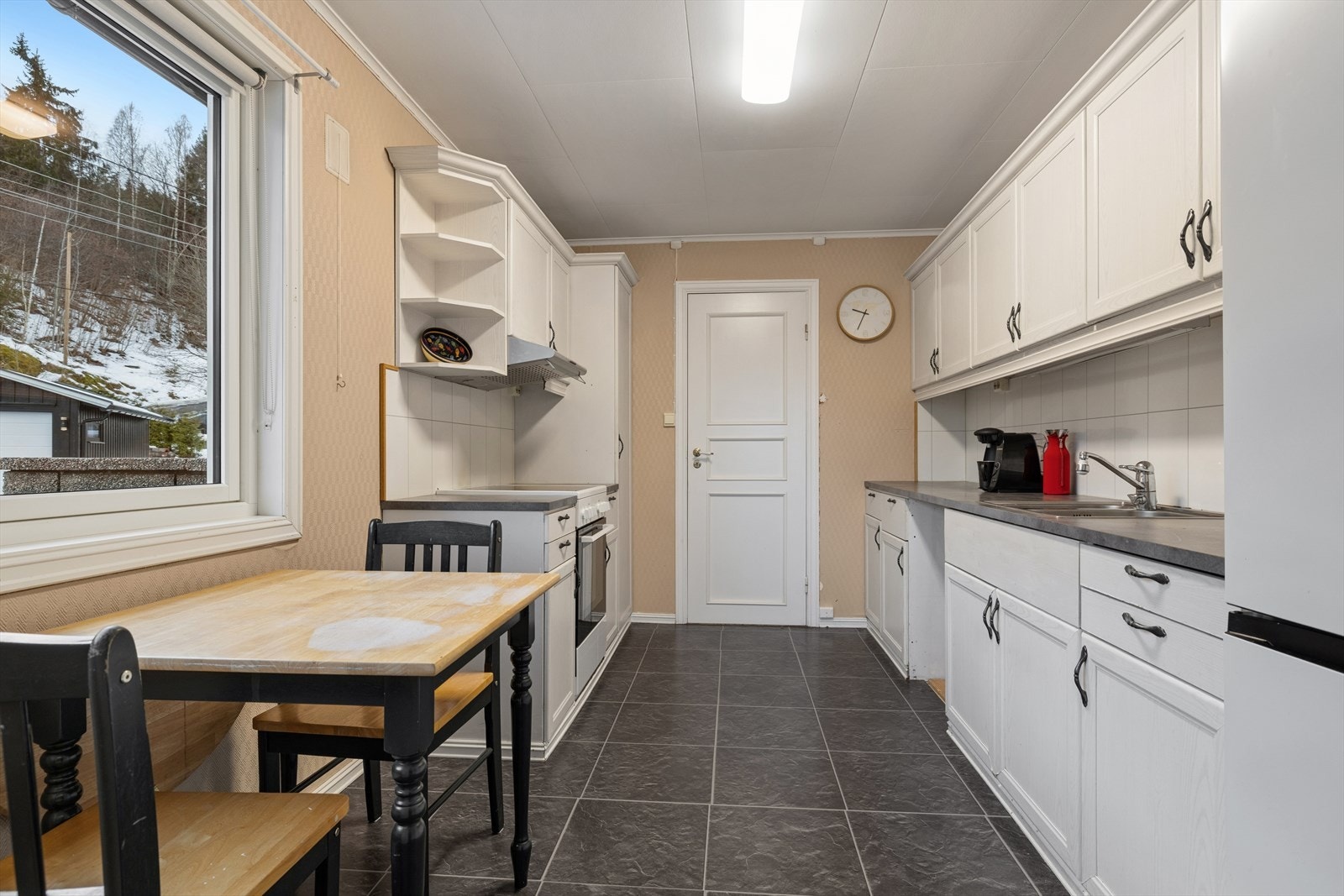 Lyst og tidløst kjøkken med alt en måtte trenge av skap-, skuff- og benkeplass. Galleribilde