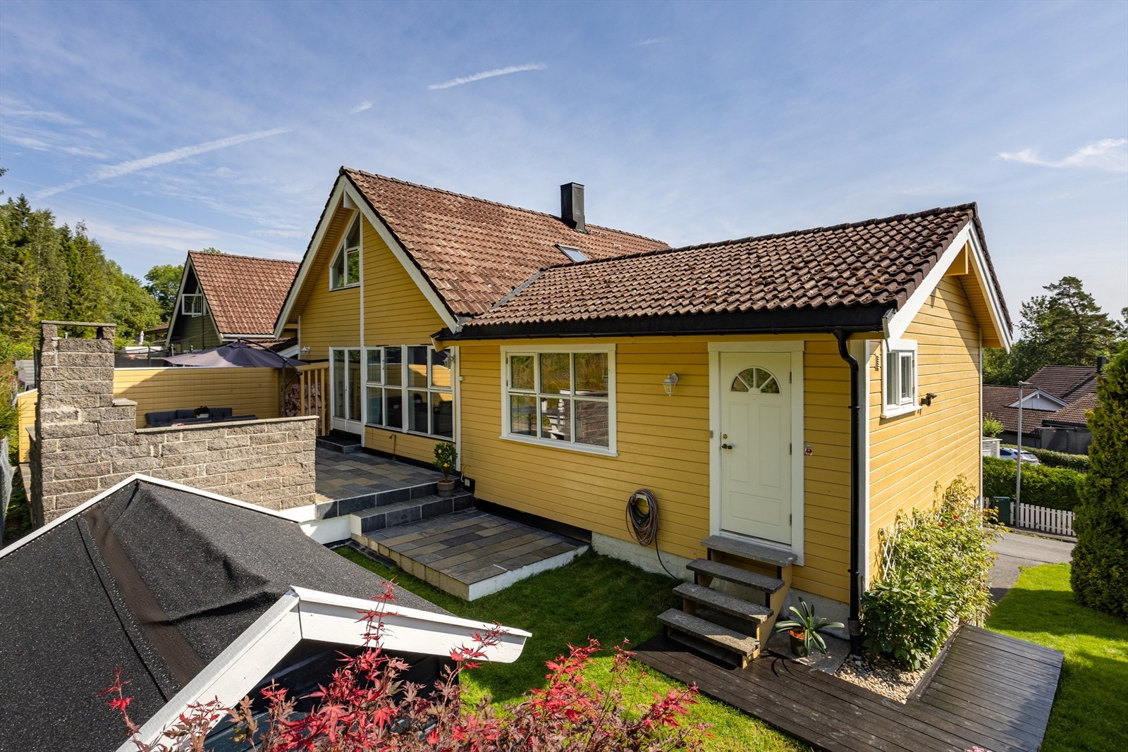 Skjermet hage med dukkehus øverst mot skogholt. Baksiden av boligen får sol fra ca. kl 13-19 i sommerhalvåret. Galleribilde