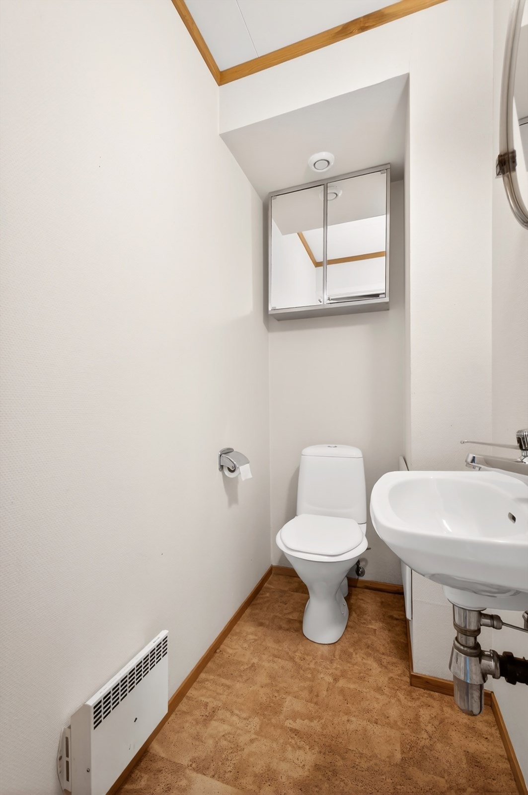 Det er et separat tolatterom i underetasjen. Rommet er innredet med gulvstående toalett og servant med speil og belysning over. Galleribilde