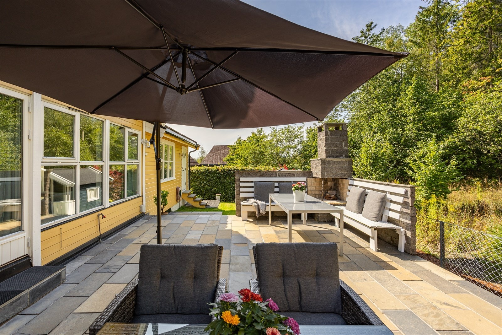 Fra stuen og entréen er det utgang til stor skiferbelagt terrasse med peis. God plass til utemøblement med flere sittegrupper. . På baksiden er det utebelysning og vanntilgang. Galleribilde