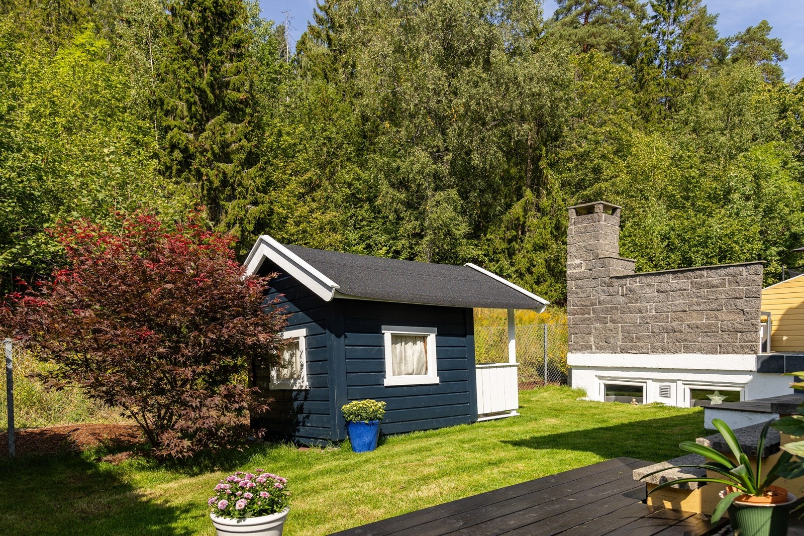 Tomten er sydvestvendt, pent opparbeidet med plen og busker. Det ble lagt ny ferdigplen i 2025. Galleribilde