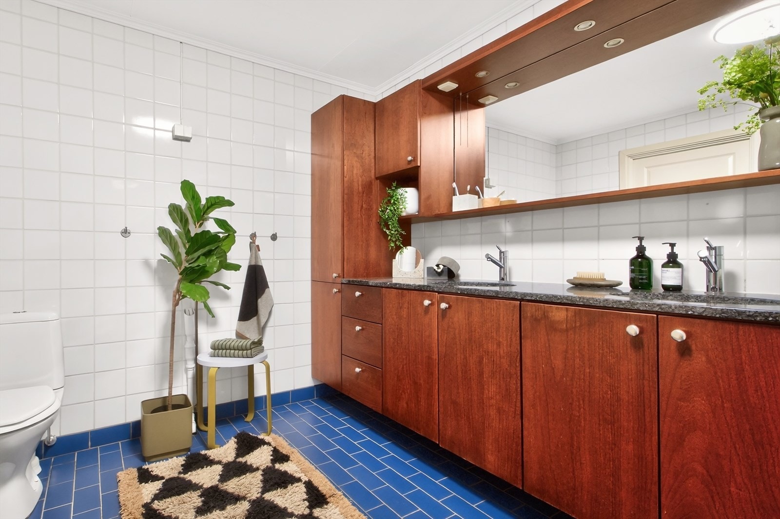 Rommet er innredet med servant med dobbel servantløsning, dusjkabinett, badekar, gulvstående toalett og opplegg for vaskemaskin. Ny taklampe og lys i overskap 2026. Galleribilde