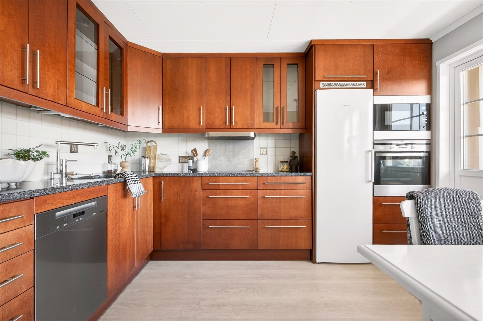 Innredet med over- og underskap med slette fronter, stein benkeplate og underlimt vask med ettgreps blandebatteri. Det er ventilator over koketopp med avtrekk til det fri. Galleribilde