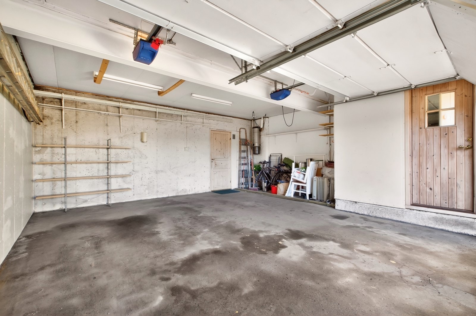 Romslig dobbeltgarasje med plass til ekstra oppbevaring. Garasjeport med elektrisk åpner. Fra garasjen er det direkte inngang til kjellerstuen. Galleribilde