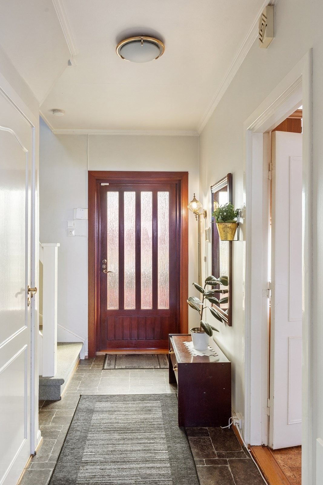 Man kommer inn i praktisk entre med trapperom som leder til 2.etasje og kjeller Galleribilde