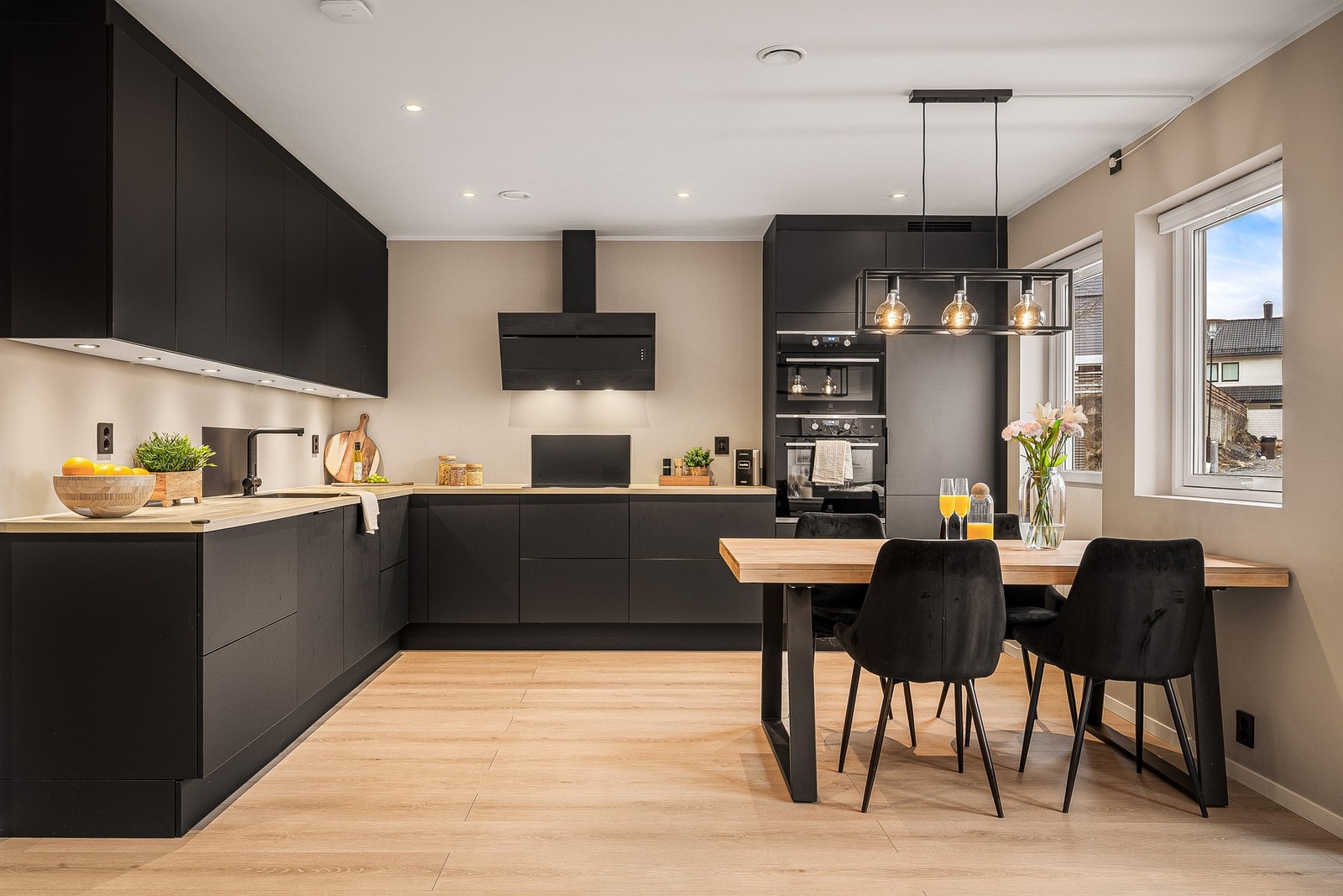 Pent og funksjonelt kjøkken med laminat på gulv og malte slette vegger og tak. Galleribilde