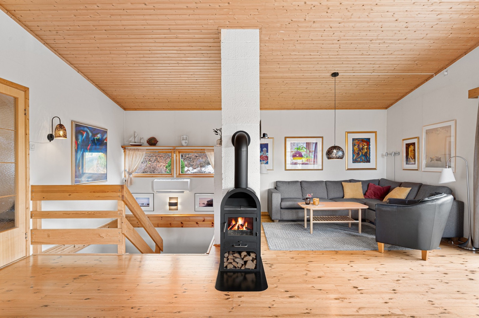 Herlig romfølelse i stua. Bredt og fint trappeløp ned mot underetasjen, med trapperepos, før trappa snur seg midtveis. Fint med vinduer også over trappeløpet. Galleribilde