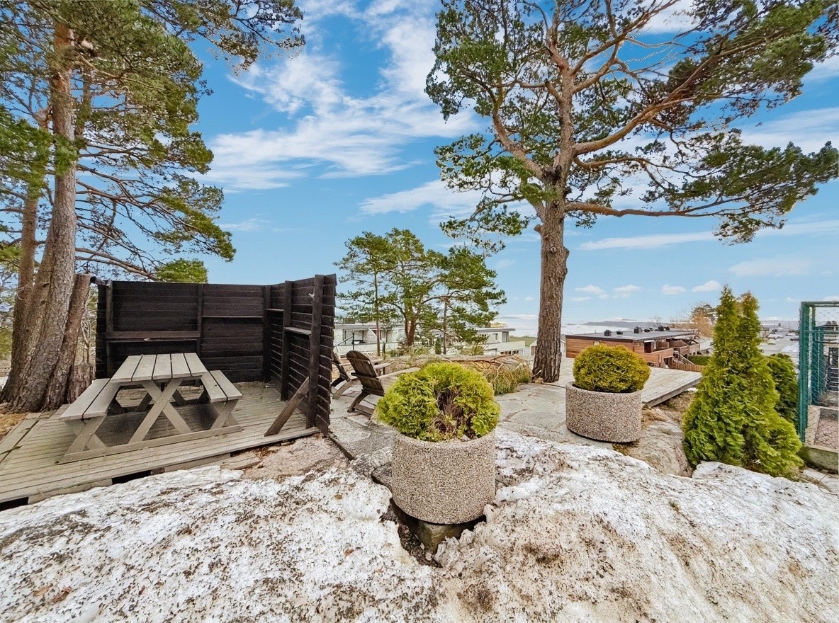 Felles uteområde med benker, terrasse og utsikt mot sjøen Galleribilde