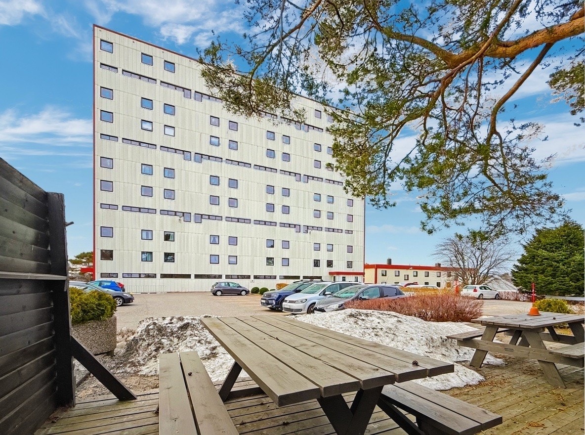 Picnic-område mellom byggene med bord og utsyn Galleribilde