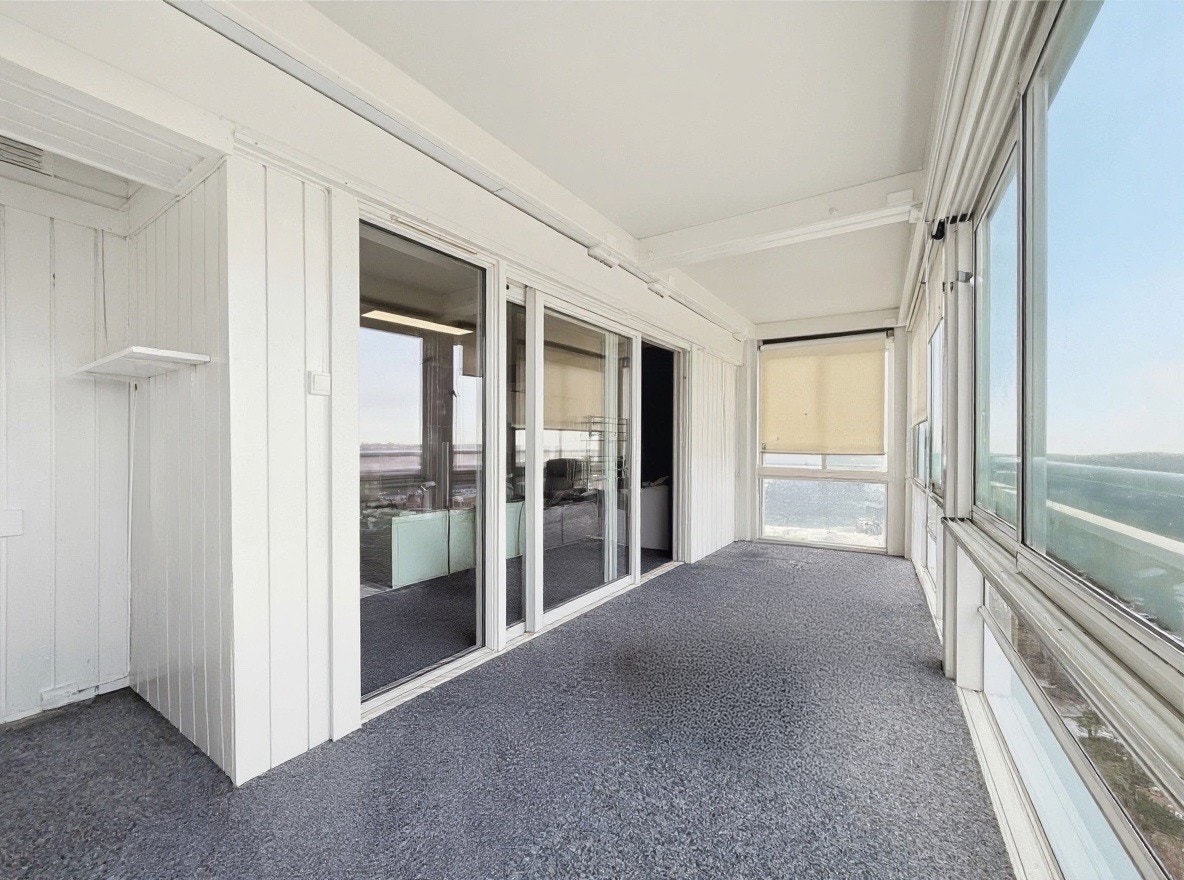 Utgang fra stuen til balkongen med glassvegger og markiser Galleribilde