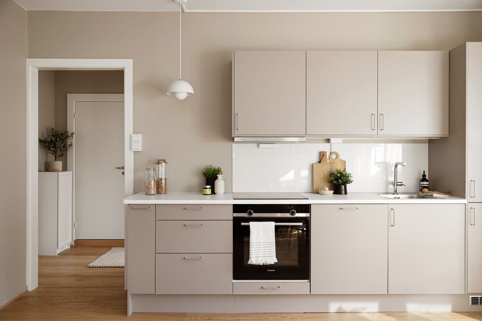 Kjøkkenet fremstår som moderne og stilrent med innredning fra HTH med glatte fronter som gir et tidløst uttrykk Galleribilde