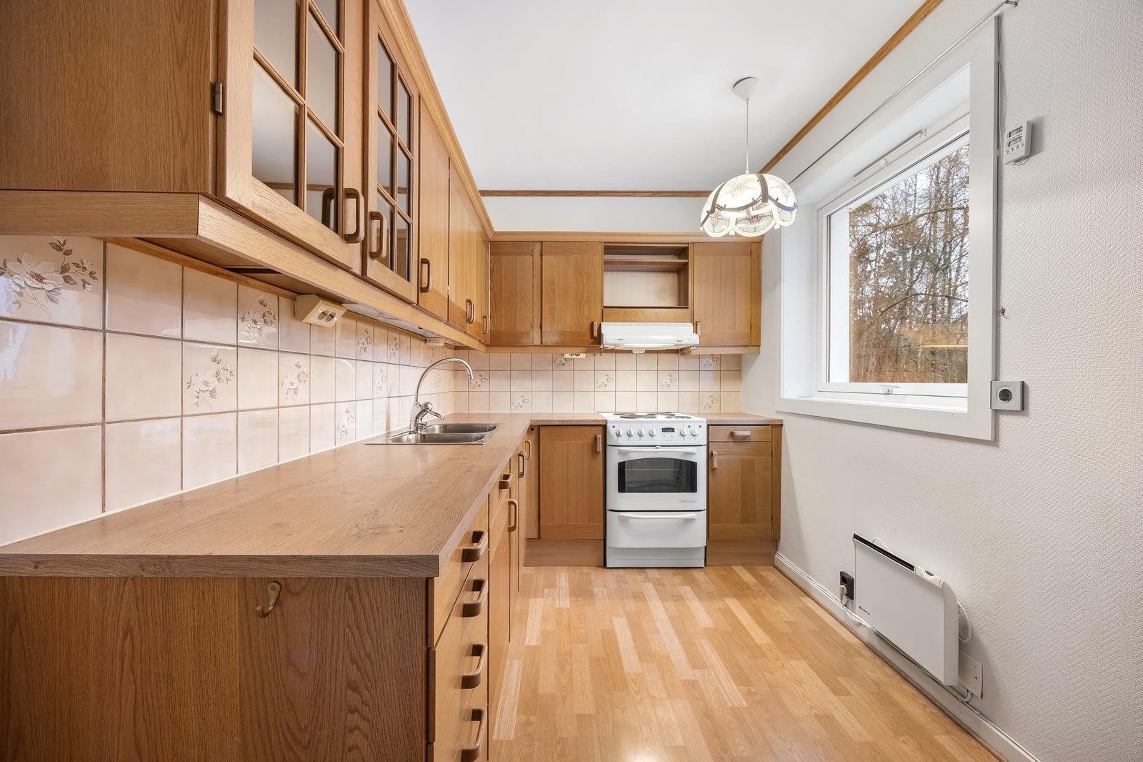 Ved vinduet er det plass til et lite frokostbord. Rommet har laminat på gulv og kullfilterventilator. Galleribilde