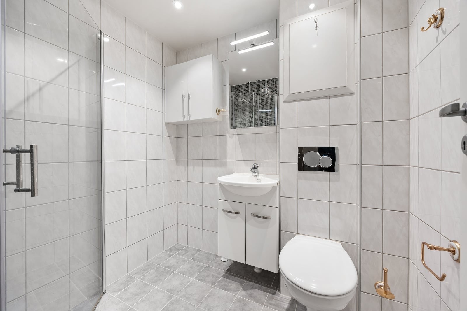 Badet er utstyrt med vegghengt toalett, servant med underskap og har opplegg for vaskemaskin. Galleribilde