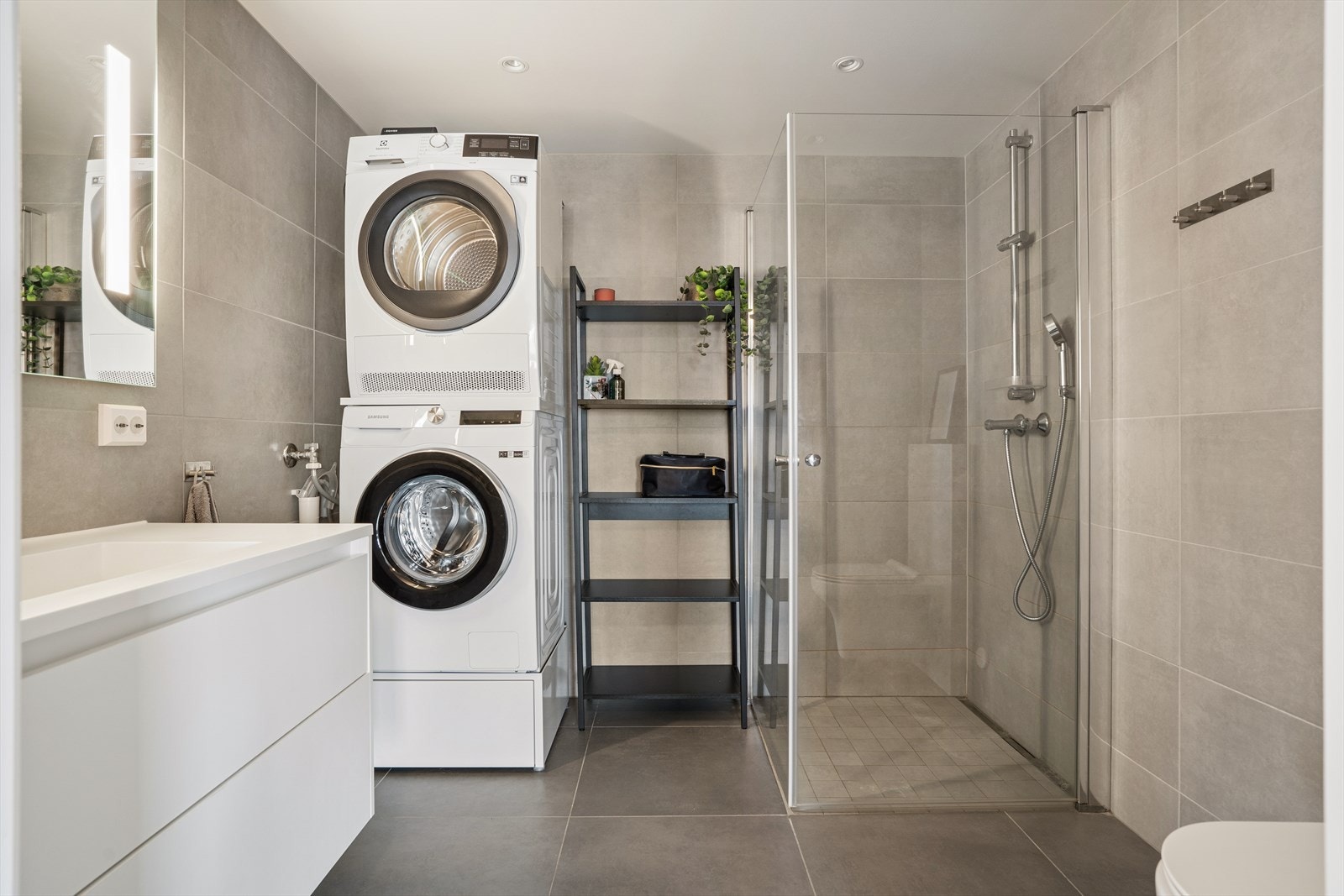 Flislagt baderom med elektriske varmekabler og dusjhjørne med glassdører. Galleribilde