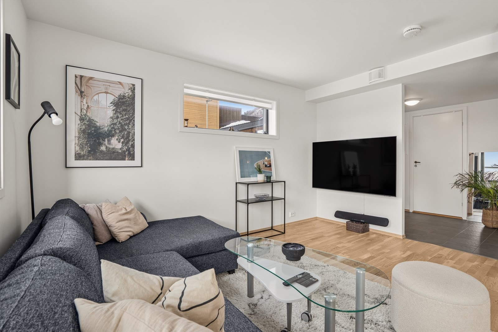 Stue med parkettgulv og vegger med malte plater gir et ryddig inntrykk. Galleribilde