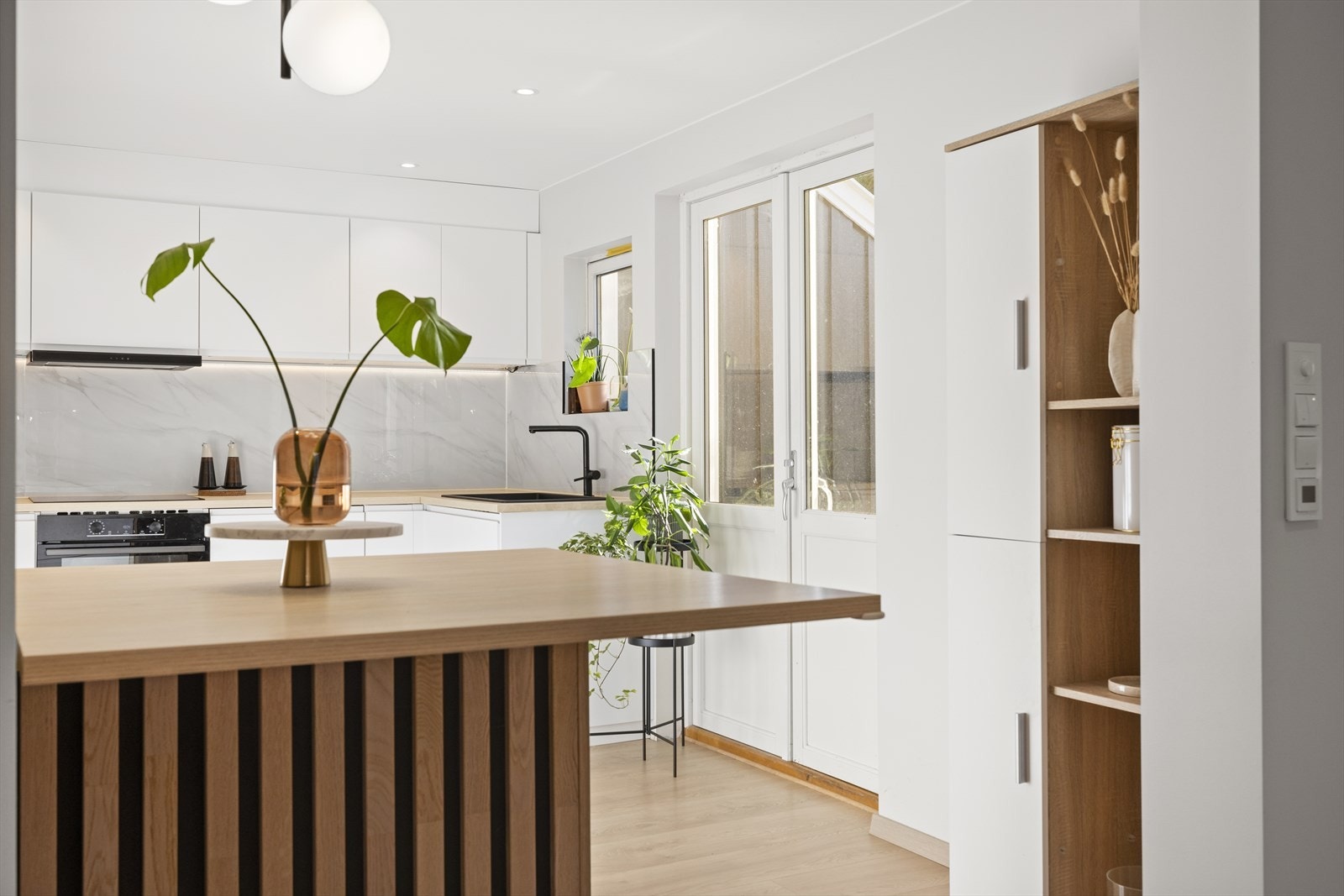 Pent kjøkken i åpen løsning med stue og spisestue. Galleribilde