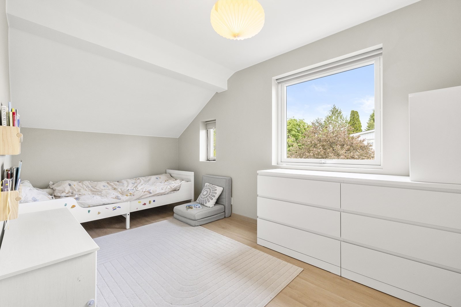 Soverom II er benyttet som barnerom og møblert med seng og kommoder. Lyse overflater, parkett på gulv og fine vindusflater. Galleribilde