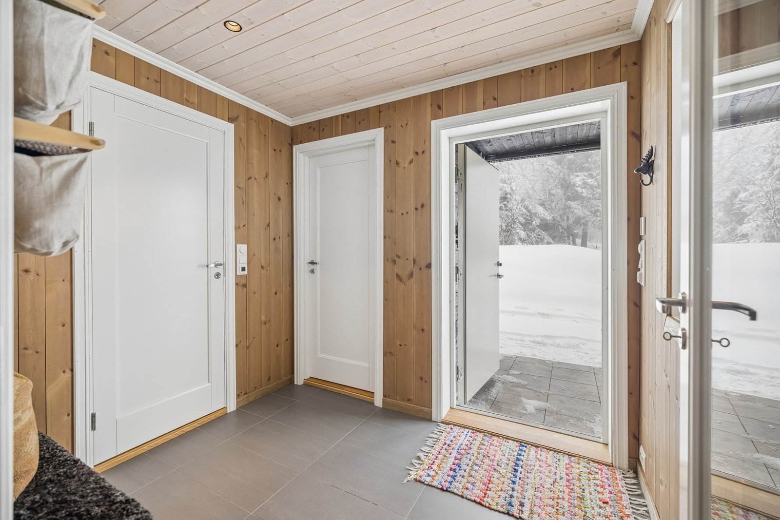 Velkommen inn i en romslig gang med fliser og gulvarme - en lun og behagelig velkomst. Galleribilde
