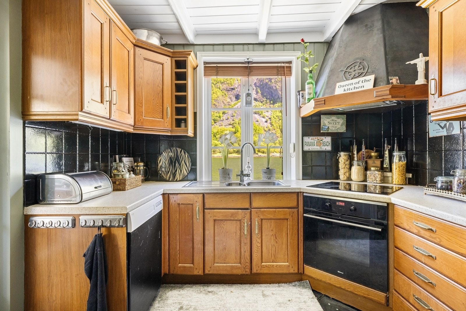 Kjøkkenet er av profilerte fronter, har laminat benkeplate, stål oppvaskkum, ventilator og fliser over benkeplaten. Galleribilde