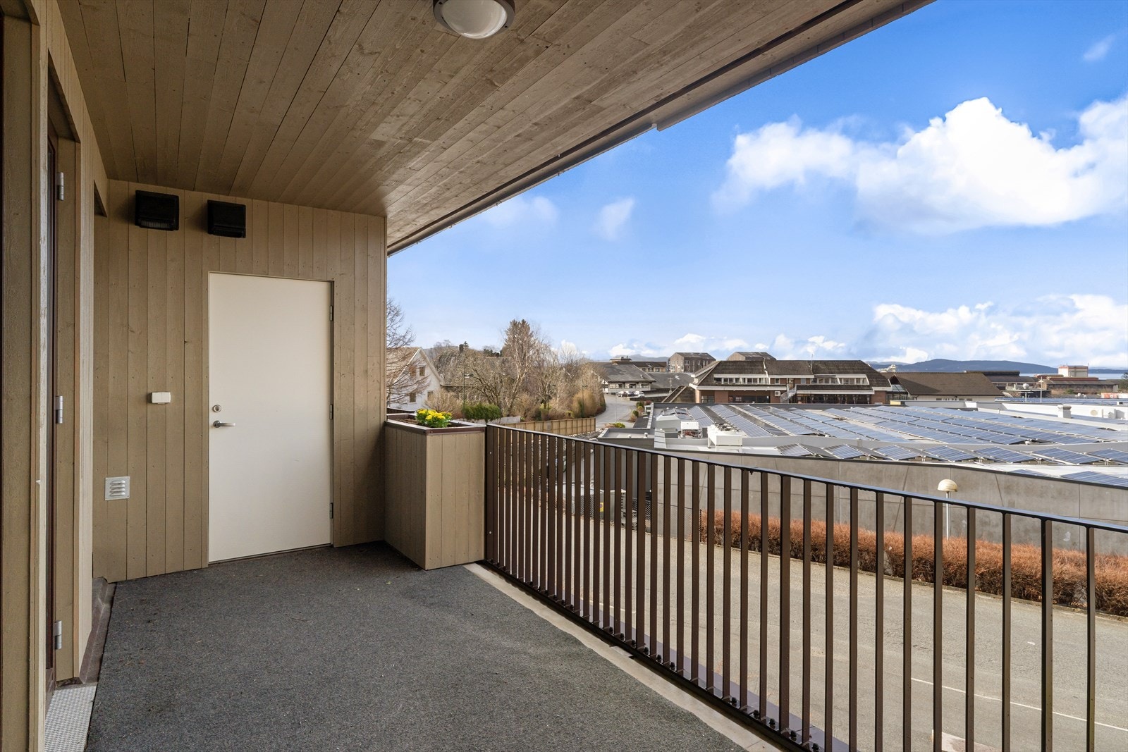 Utgang til delvis overbygd terrasse fra stue, med en liten utvendig bod Galleribilde