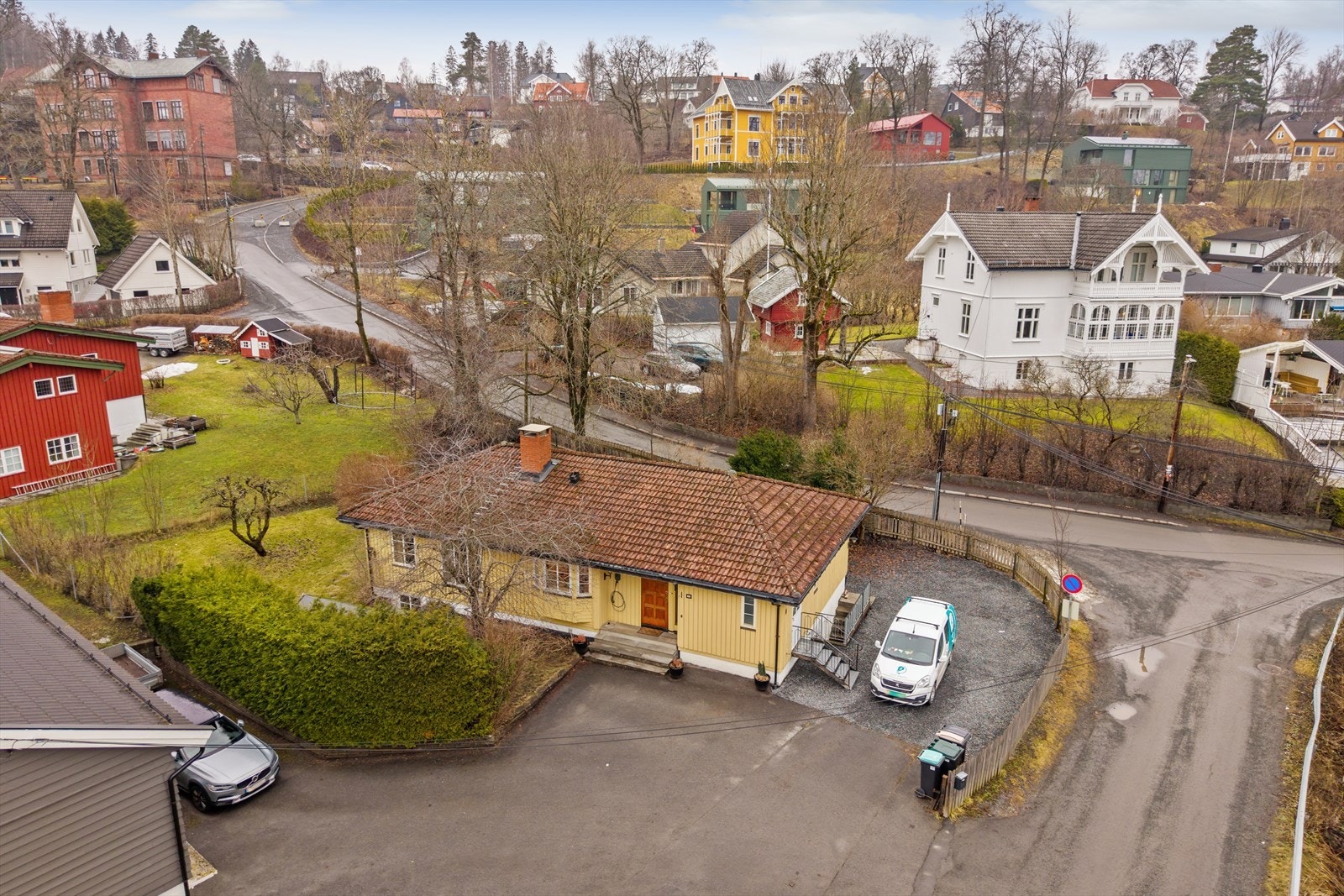 Tomten er opparbeidet med asfaltert gårdsplass, plenarealer og beplantning. Galleribilde