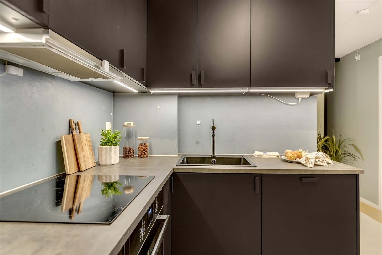 Videre har kjøkkenet kum med ettgreps blandebatteri og praktisk belysning under overskapene. Galleribilde