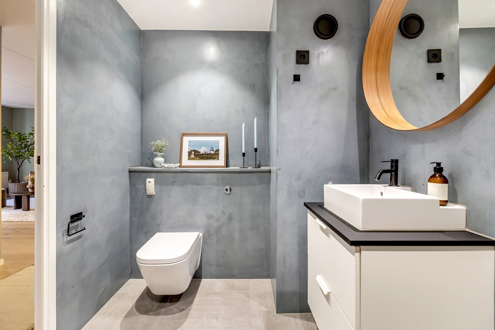 Badet er utstyrt med veggmontert WC, servant med ettgreps blandebatteri og baderomsinnredning med gode oppbevaringsmuligheter. Det er opplegg for vaskemaskin og downlight i himling. Galleribilde