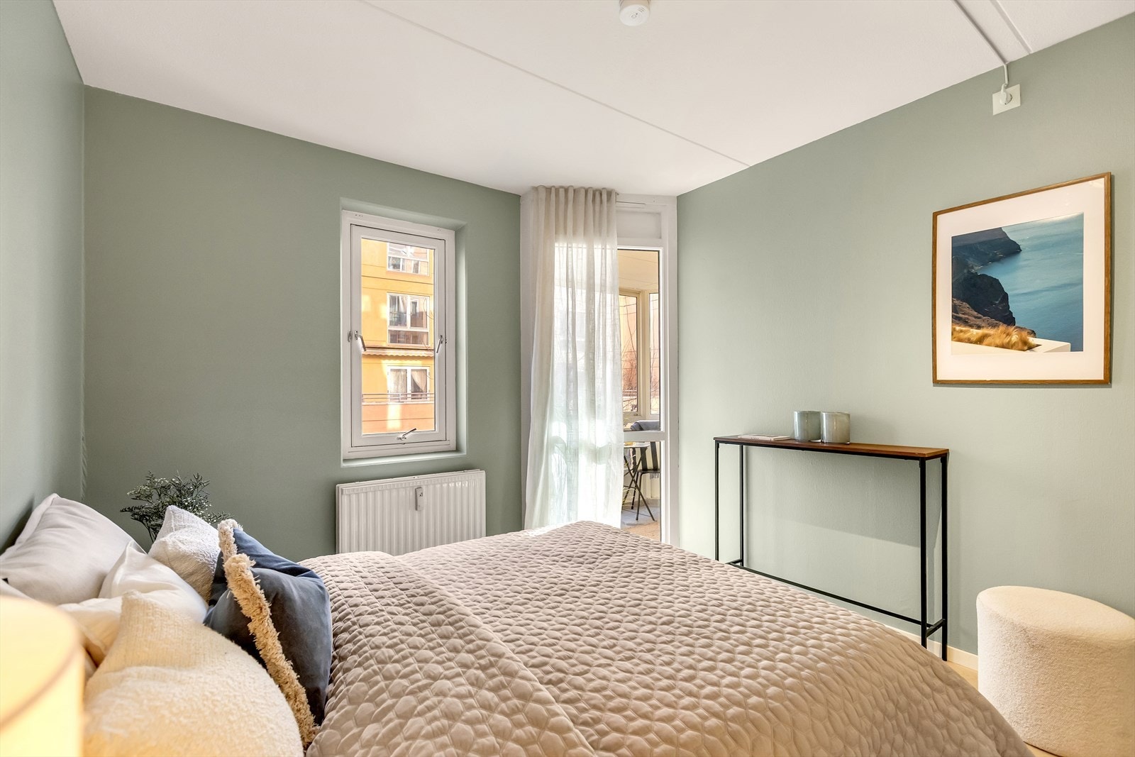 Store vindusflater gir godt med naturlig lys, og rommet har god plass til dobbeltseng med tilhørende møblement. Galleribilde