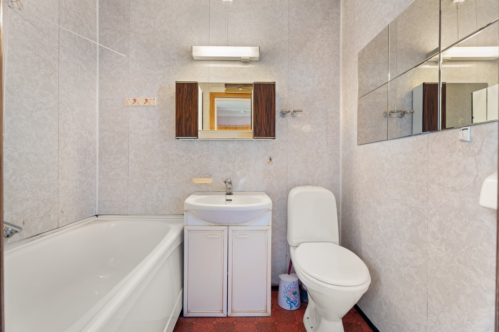 Badet er utstyrt med toalett, servantskap og badekar. Det er våtromsplater (respatex) i veggene, belegg på gulv og malte plater i tak. Renovering må påregnes. Galleribilde