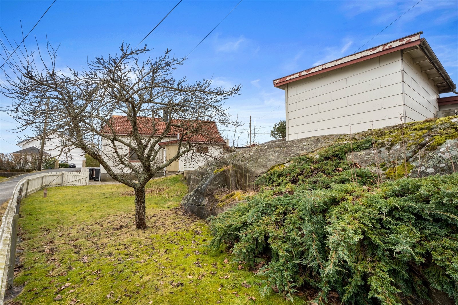 Tomten er pent opparbeidet med en lett skrående tomt med hage, busker og diverse beplantninger. Galleribilde